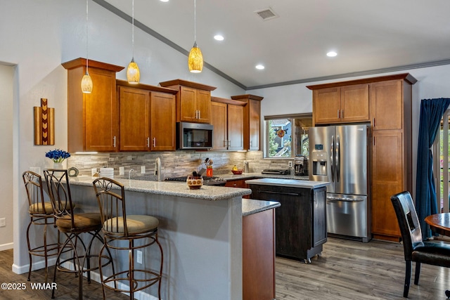 721 S Reynolds Ln, Show Low, AZ 85901 - kitchen with appliances with stainless steel finishes, a peninsula, tasteful backsplash, brown cabinetry, and ornamental molding