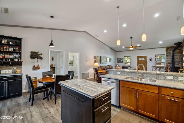 721 S Reynolds Ln, Show Low, AZ 85901 - kitchen featuring dishwasher, a wood stove, open floor plan, light wood-style flooring, and lofted ceiling