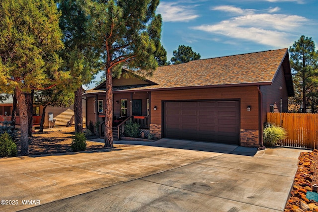 721 S Reynolds Ln, Show Low, AZ 85901 - view of front facade featuring concrete driveway, a garage, stone siding, and a shingled roof