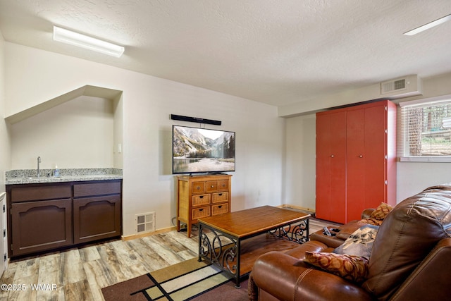living room with light wood-style floors and a textured ceiling