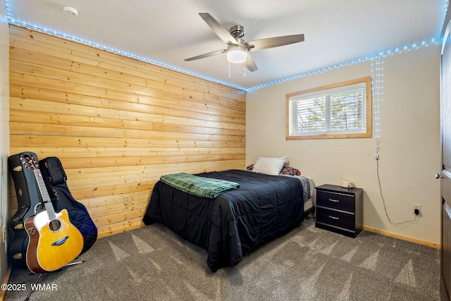 bedroom featuring carpet, wood walls, a ceiling fan, and baseboards