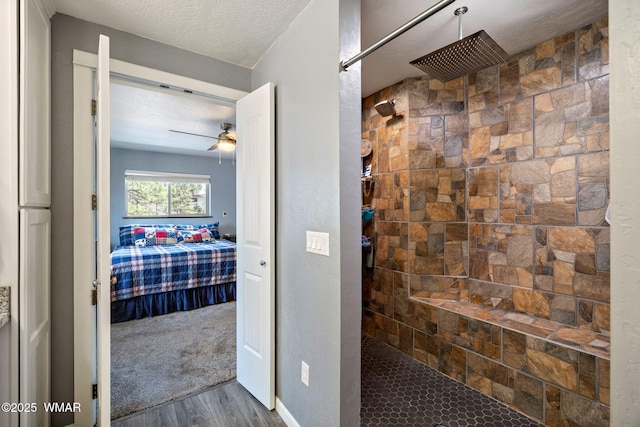 full bathroom featuring ceiling fan, tiled shower, wood finished floors, a textured ceiling, and connected bathroom