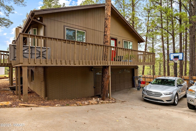 view of front of home with concrete driveway, an attached garage, and a deck