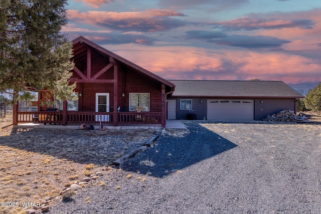 chalet / cabin featuring driveway and an attached garage