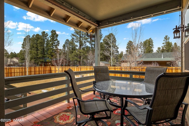 wooden terrace featuring outdoor dining area and a fenced backyard