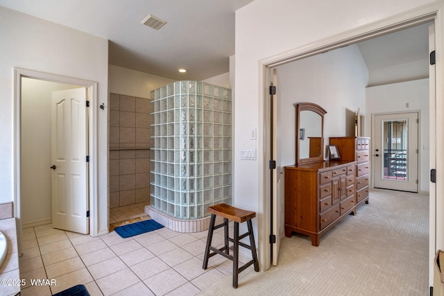 bathroom with tile patterned floors, visible vents, walk in shower, and vanity