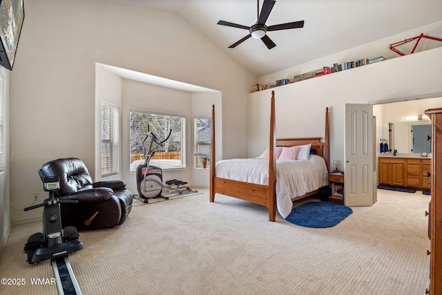 bedroom with a ceiling fan, ensuite bathroom, light colored carpet, and high vaulted ceiling