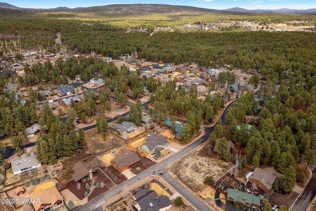 birds eye view of property featuring a wooded view, a mountain view, and a residential view