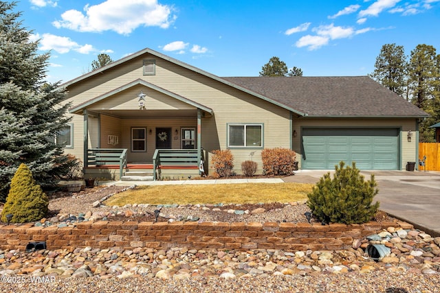 view of front of house with an attached garage, covered porch, driveway, and roof with shingles