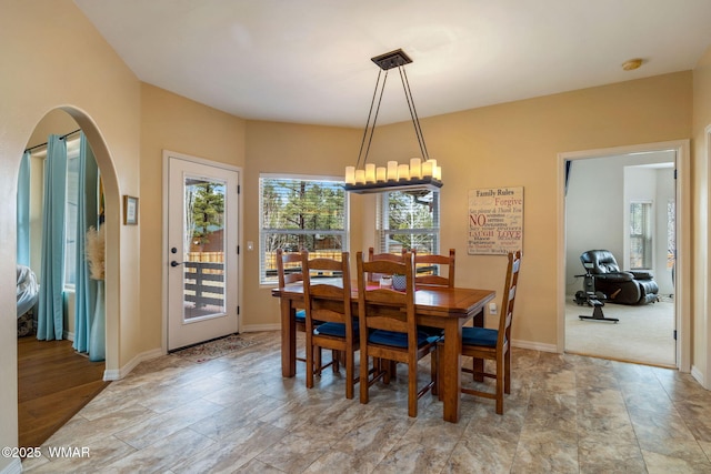 dining space featuring baseboards and arched walkways