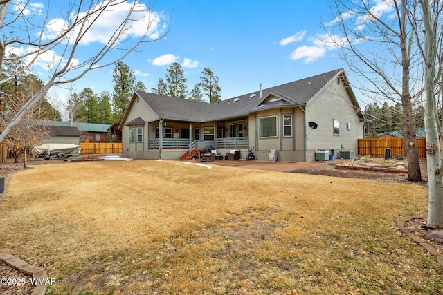 back of house featuring central air condition unit, a yard, and fence