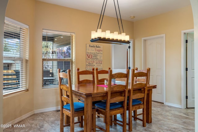 dining area with a chandelier and baseboards