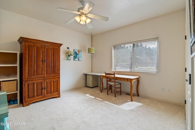 office area featuring a ceiling fan, baseboards, and light carpet