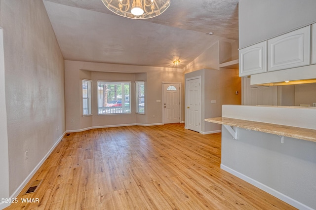 880 N 46th Dr, Show Low, AZ 85901 - unfurnished living room with vaulted ceiling, light wood-style floors, and a chandelier