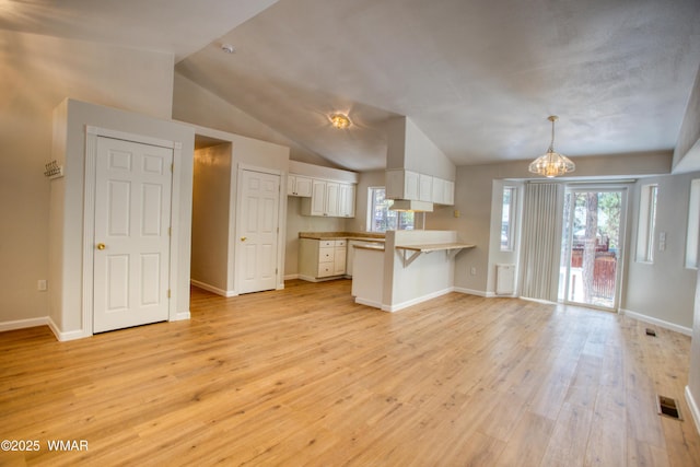 880 N 46th Dr, Show Low, AZ 85901 - kitchen featuring a peninsula, white cabinetry, light wood finished floors, a breakfast bar area, and a chandelier