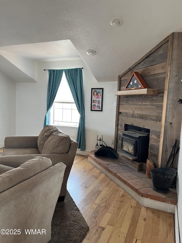 8515 Pueblo Ln, Snowflake, AZ 85937 - living room with a textured ceiling, wood-type flooring, a wood stove, and lofted ceiling