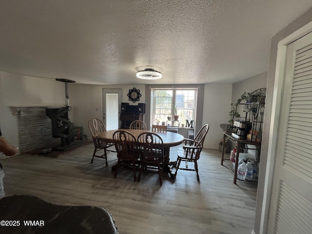 8515 Pueblo Ln, Snowflake, AZ 85937 - dining area featuring wood finished floors, a wood stove, and a textured ceiling