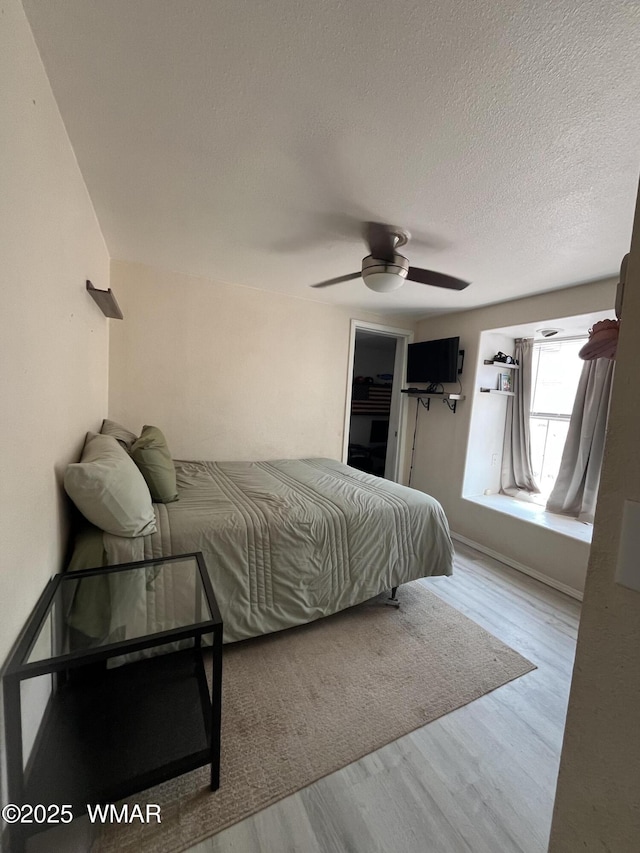 8515 Pueblo Ln, Snowflake, AZ 85937 - bedroom with wood finished floors, a textured ceiling, and a ceiling fan