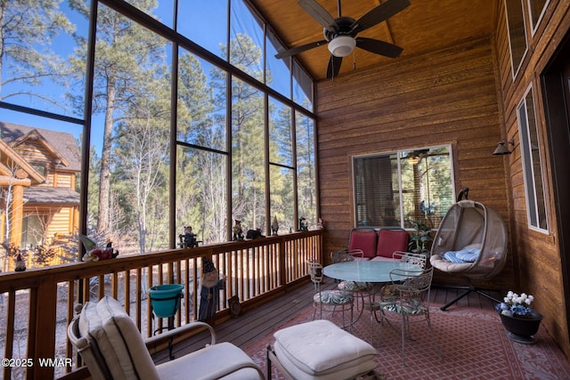sunroom / solarium featuring a ceiling fan, plenty of natural light, and outdoor dining space