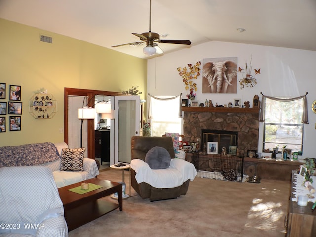 living area with a fireplace, lofted ceiling, visible vents, carpet flooring, and ceiling fan