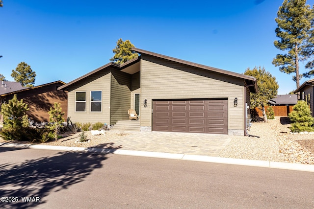 mid-century modern home with an attached garage and decorative driveway