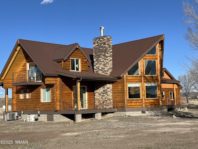 446 Becker Lake Rd, Springerville, AZ 85938 - view of front of home featuring cooling unit, a chimney, metal roof, and a balcony