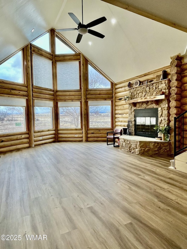 446 Becker Lake Rd, Springerville, AZ 85938 - unfurnished living room with beam ceiling, a fireplace, high vaulted ceiling, a ceiling fan, and rustic walls