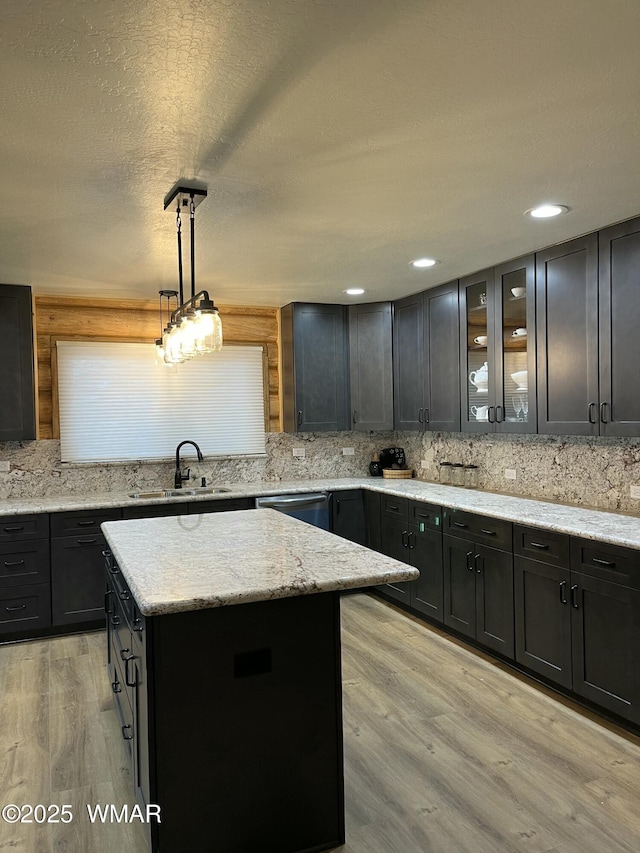 446 Becker Lake Rd, Springerville, AZ 85938 - kitchen with a sink, dishwasher, light wood-style flooring, a center island, and decorative backsplash