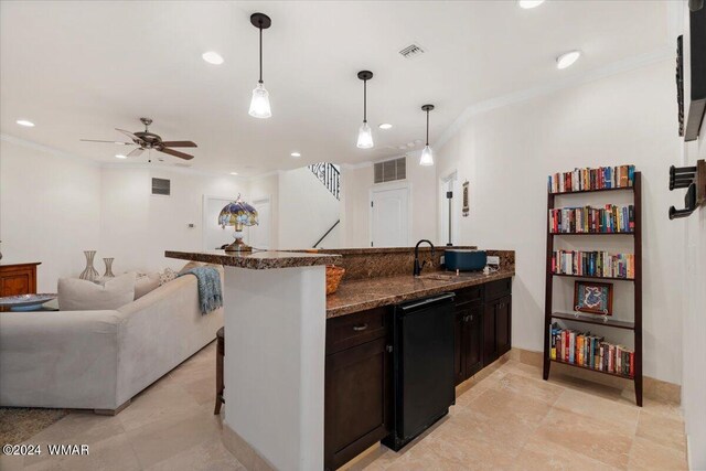 kitchen featuring open floor plan, crown molding, a breakfast bar area, and pendant lighting