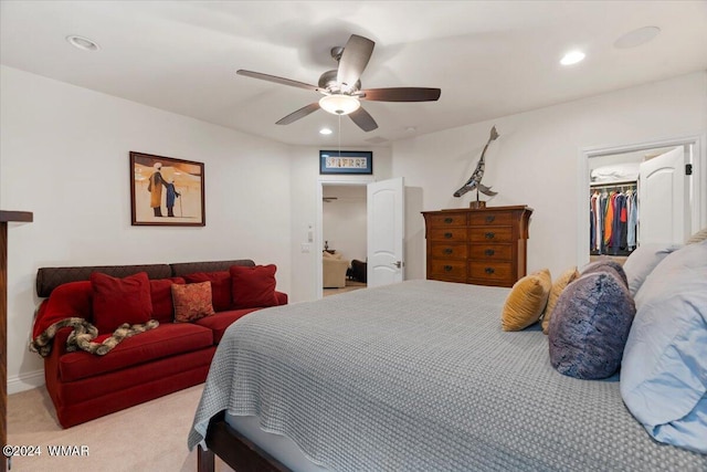 bedroom with a ceiling fan, recessed lighting, light carpet, and a spacious closet