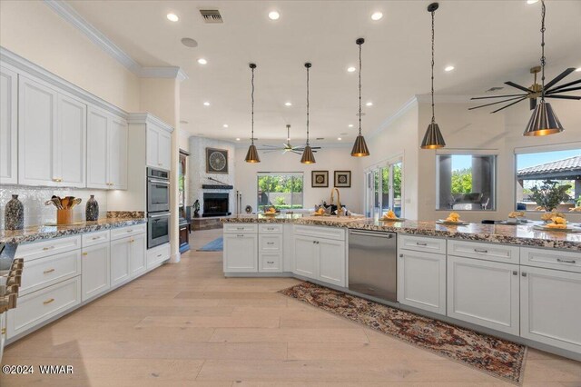 kitchen with visible vents, white cabinets, appliances with stainless steel finishes, open floor plan, and pendant lighting