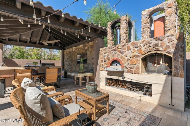 view of patio / terrace with outdoor dining space, an outdoor stone fireplace, and a gazebo