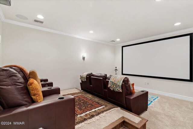 home theater room with ornamental molding, visible vents, and light colored carpet