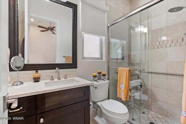 bathroom with toilet, ceiling fan, a stall shower, and vanity