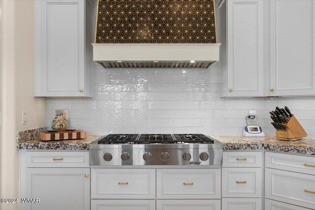 kitchen featuring custom range hood, decorative backsplash, white cabinetry, and stainless steel gas stovetop