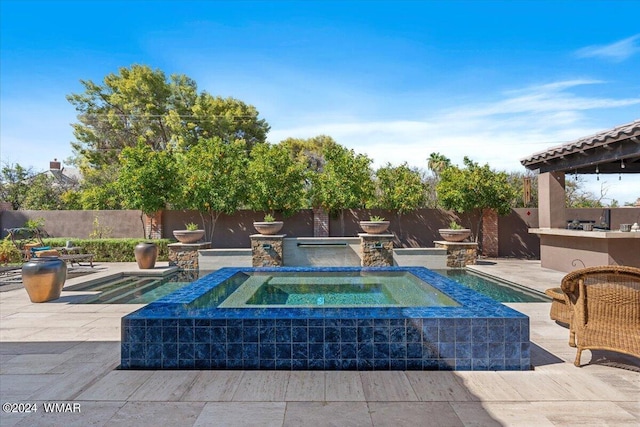 view of swimming pool featuring a patio area, a fenced backyard, a fenced in pool, and an in ground hot tub