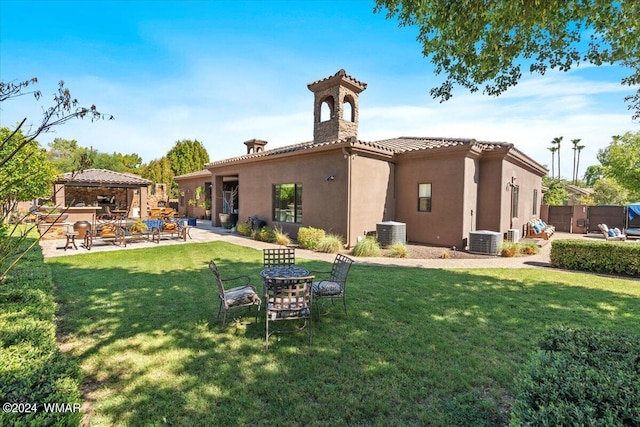 back of house featuring a gazebo, fence, cooling unit, a yard, and stucco siding