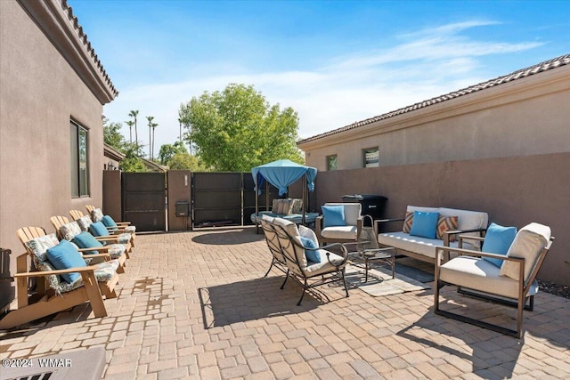 view of patio with a gate, fence, and outdoor lounge area