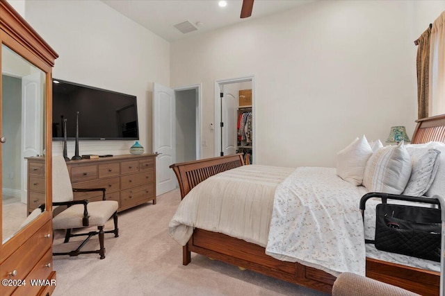 bedroom featuring a spacious closet, visible vents, and light colored carpet