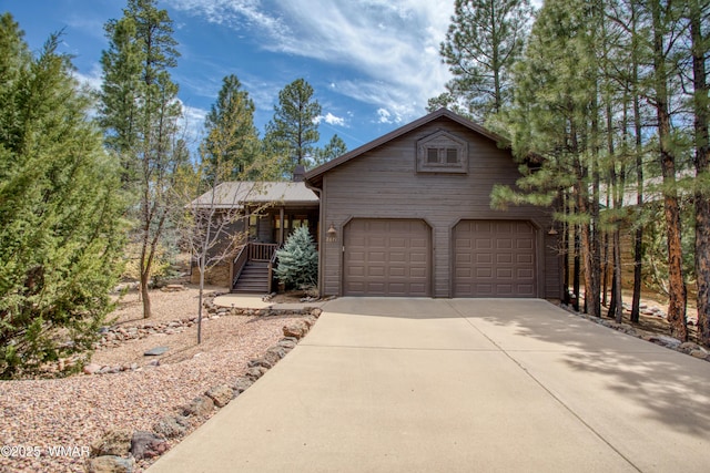 rustic home featuring covered porch and concrete driveway