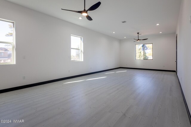 spare room featuring recessed lighting, visible vents, light wood-style floors, a ceiling fan, and baseboards