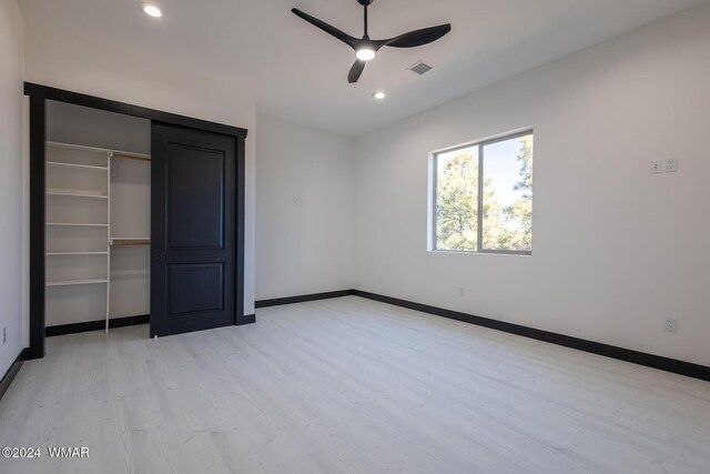 unfurnished bedroom featuring baseboards, visible vents, light wood-style floors, a closet, and recessed lighting