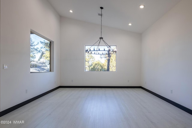 spare room with lofted ceiling, light wood-style flooring, baseboards, and recessed lighting