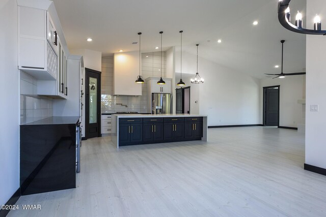 kitchen with decorative light fixtures, open floor plan, white cabinets, and a large island