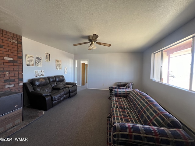 living area featuring carpet floors, ceiling fan, a textured ceiling, and baseboards