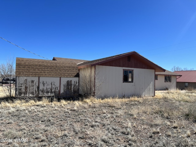 view of property exterior with roof with shingles