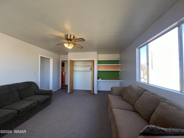 living area with carpet floors and ceiling fan