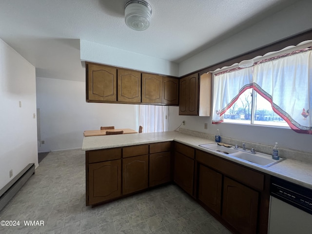 kitchen with light countertops, white dishwasher, a sink, and a peninsula