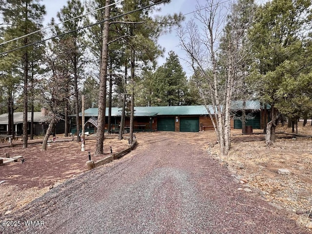 chalet / cabin with dirt driveway and a garage