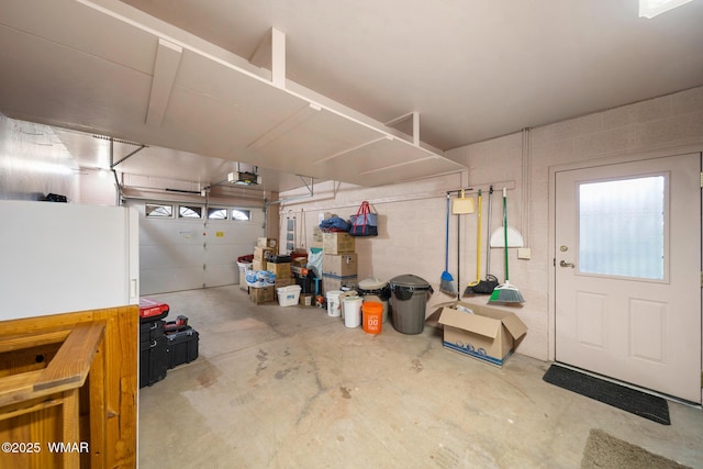 garage featuring concrete block wall and a garage door opener